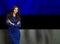 Pretty young woman standing against Estonian flag background