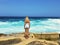 Pretty young woman standing on rock looking at bright sea waves,outdoor,fashion model,believe in hope,traveling tourist,feel free