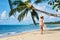 Pretty young woman in white bikini walking barefoot on the sea shore on tropical beach