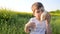 Pretty youngster with loaf bread and glass in hand on background field, little boy eating food in park outdoors