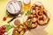 Pretzels, white bavarian sausages, mustard and beer, german traditional food, oktoberfest on yellow background