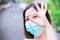 Prevent spread of coronavirus and PM2.5 toxic dust, air pollution problem. Head shot of woman wearing green medical face mask.