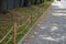 Preventing entry to grassy areas by means of wooden poles with two jute ropes of the edge at the sidewalk made of small granite