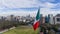 Pride in the Breeze: Massive Mexican Flag Soars Over Mexico City, Framed by Urban Splendor and Majestic Mountains