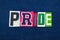 PRIDE collage of word text, multi colored fabric on blue denim, LGBTQ inclusion concept