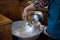 The priest assistant filled Christening Baptismal Font with Holy Water at the church during the ceremony