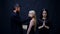 Priest blesses the girls. Concept of religion. Bearded man in black and two girls pray on black background. Religion is