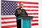 Priest giving a speech on a podium in front of USA flag