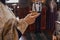 A priest in a golden cassock holds a small mug of sacred red wine