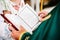 The priest holds and read the Bible in his hands. Priest during a wedding ceremony, celebrate a mass at the church. Close up