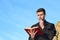 Priest kissing a rosary while reading the bible