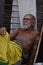 Priest portrait image in Badavilinga Temple with stick wearing yellow dhoti relaxing /Shiva Linga Hampi
