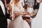 Priest putting on golden wedding ring on bride finger. Wedding m