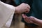 Priest serving holy communion placing the bread in the hands of the parishioner