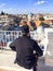 Priest sitting with view on rooftops of Old City of Jerusalem