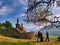 A priest and two faithful praying in front of the Pindreau monument, place of the Marian apparition of Our Lady of Laus.