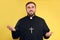 Priest wearing cassock with clerical collar on yellow