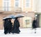 Priests with umbrellas walking in motion blur in winter snowy day