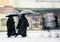 Priests with umbrellas walkPriests with umbrellas walking in motion blur in winter snowy daying in motion blur in winter snowy day