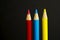 Primary coloured pencil crayons on a black background