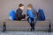 Primary education, school, friendship concept - two boys with backpacks sitting, talking and playing with spinner