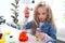 Primary school girl with long blonde hair doing chemistry science experiment in laboratory, cute scientist kid with colorful test