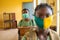 Primary school pupil`s sitting in class, wearing face masks, and observing physical distancing