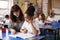 Primary school teacher helping a schoolgirl at her desk