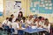 Primary school teacher with kids working on a class project