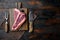 Prime cut tender raw t bone steak for a BBQ, on wooden cutting board, on old dark  wooden table background, top view flat lay,