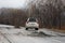 Primorsky Krai, Russia - 2016, autumn - A car drives along a bad, dead road among tall trees. Russian roads. Bad asphalt