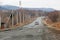 Primorsky Krai, Russia - 2016, autumn - A car drives along a bad, dead road among tall trees. Russian roads. Bad asphalt