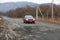 Primorsky Krai, Russia - 2016, autumn - A car drives along a bad, dead road among tall trees. Russian roads. Bad asphalt