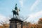 Prince Komatsu Akihito bronze statue with autumn maple at Ueno park in Tokyo, Japan