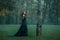 Princess with red long hair dressed in green expensive velvet royal cloak-dress, girl got lost in dark foggy forest, art