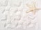 prints of a starfish on a sandy beach. sealife pattern as summer background. traces of starfish on white sand. exotic