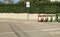 Priority to pedestrian and cyclists, warning road sign on concrete sidewalk. Concrete fence with hedge on behind, recycle bin