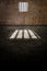 Prison cell, inside a prison cell. Window of a penitentiary. Shadows projected on the ground. Prison sentence, window bars.