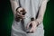 Prison and convicted topic: man with handcuffs on his hands in a gray T-shirt and blue jeans on a dark green background in the stu