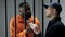 Prison guard taking euro banknotes from afro-american criminal, corruption