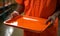 A prison inmate holding an empty canteen food tray