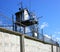 A prison tower with a concrete fence and barbed wire