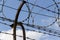 Prison wall barbed wire fence with blue sky in background