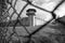 Prison watchtower protected by wire of prison fence.White prison wall and guard tower with coiled barbed wire.Criminal justice