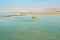 The pristine beach of the Dead Sea with cobblestones and emerging land.