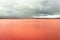 Pristine landscape with red lake calm water and dramatic sky at morning