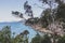 Pristine little beach surrounded by rocky cliffs with turquoise water from the Pacific Ocean, seen along the Boronia Beach coastal