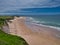 The pristine sand of Whiterocks Beach and coastal cliffs on the Antrim Causeway Coast in Northern Ireland, UK. Taken on a sunny