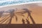 Pristine tropical beach with shadows from palm trees and happy couple on the sand