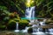 A pristine waterfall hidden within a dense, tropical jungle, surrounded by lush foliage